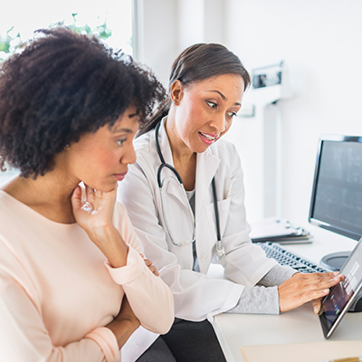 HCP explaining health needs with patient with tablet